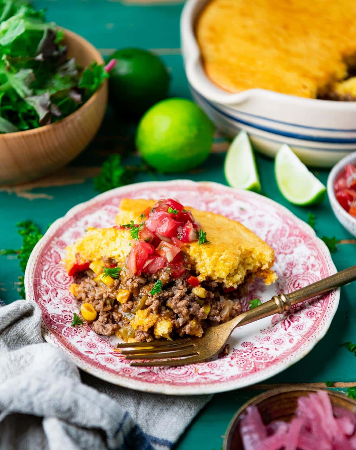 Easy taco pie recipe on a red and white plate with toppings.