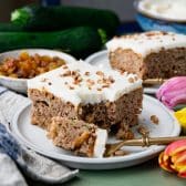 Square side shot of a slice of zucchini cake with a bite on a fork.
