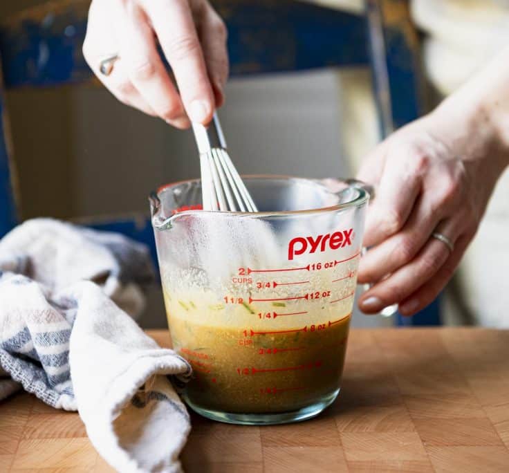 Whisking bourbon marinade for chicken thighs.
