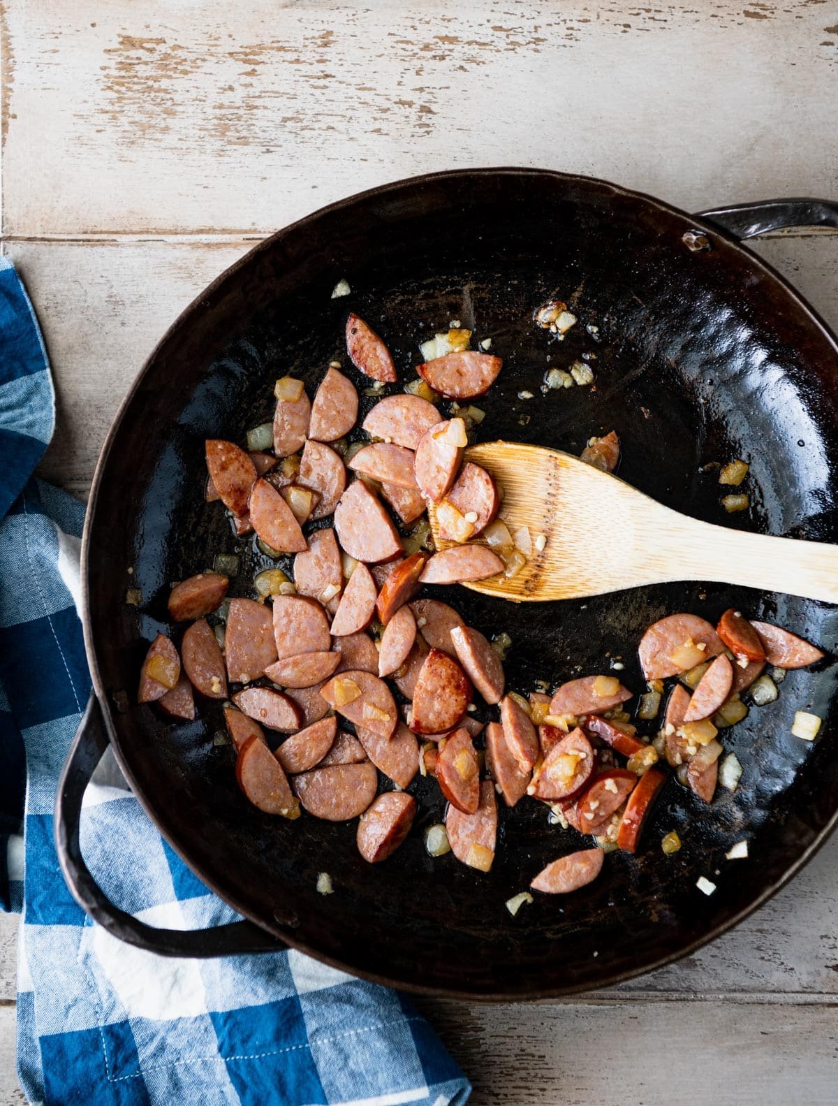 Sauteing andouille sausage in a cast iron skillet.