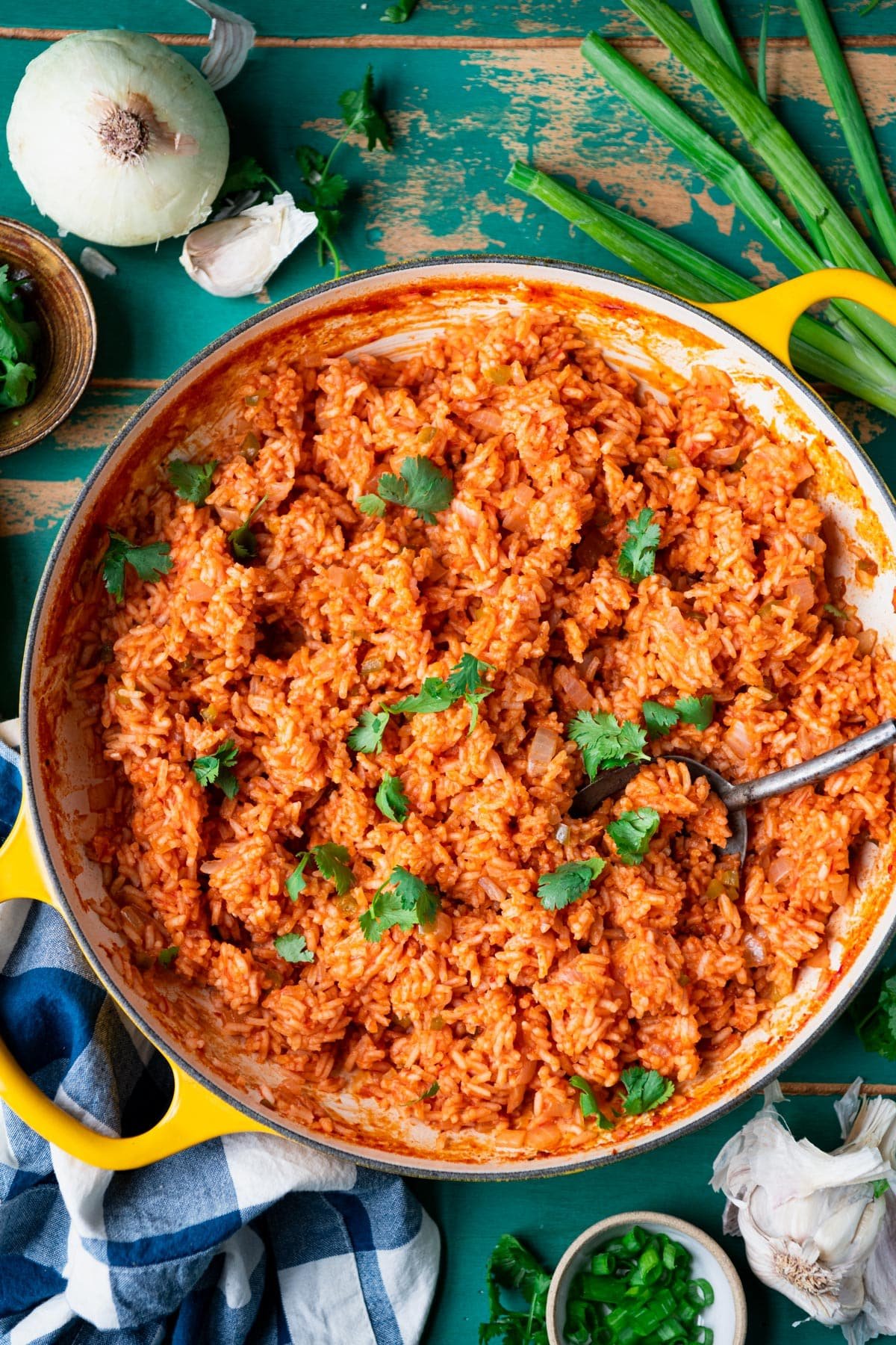 Close overhead image of a pan of the best spanish rice recipe on a wooden table.