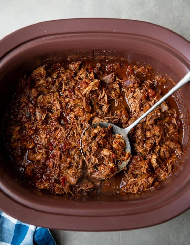 Shredded slow cooker pulled pork in a crock pot.