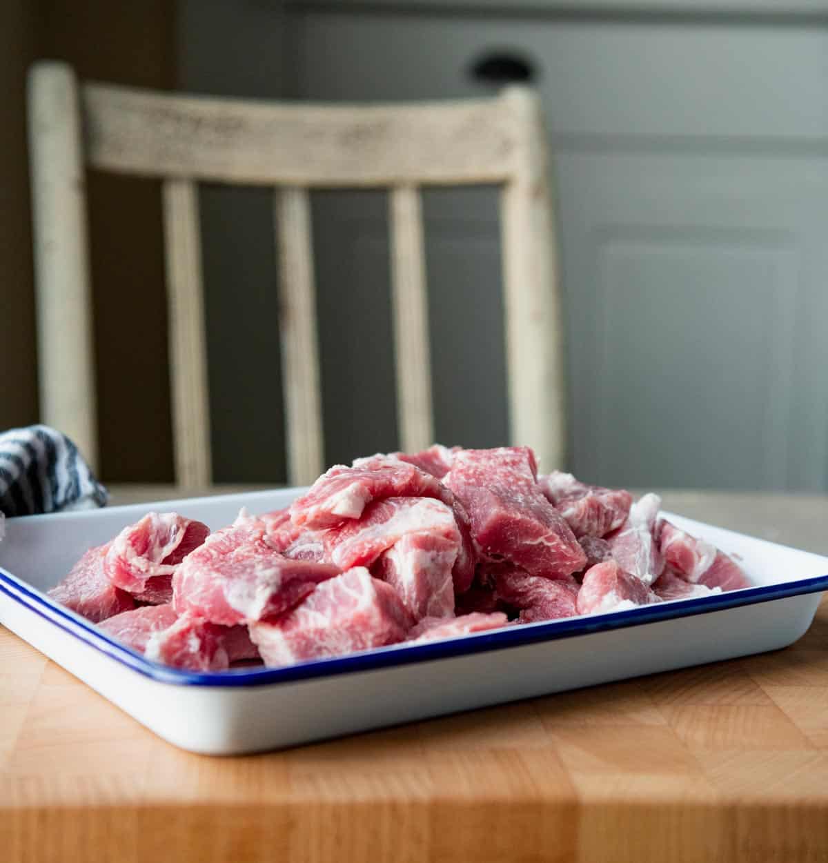Cubed pork shoulder on a tray.