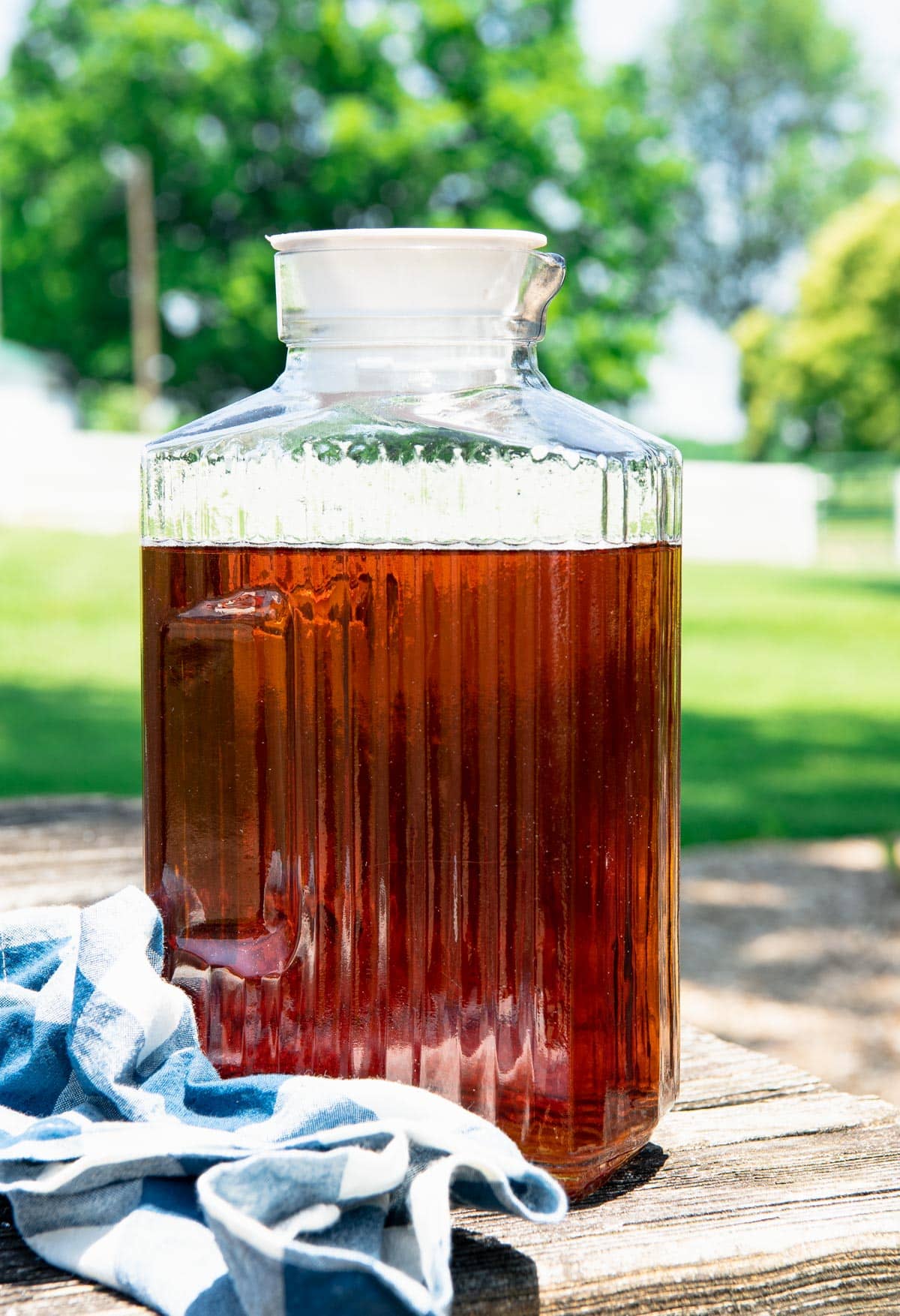 Pitcher of sun tea on a picnic table.