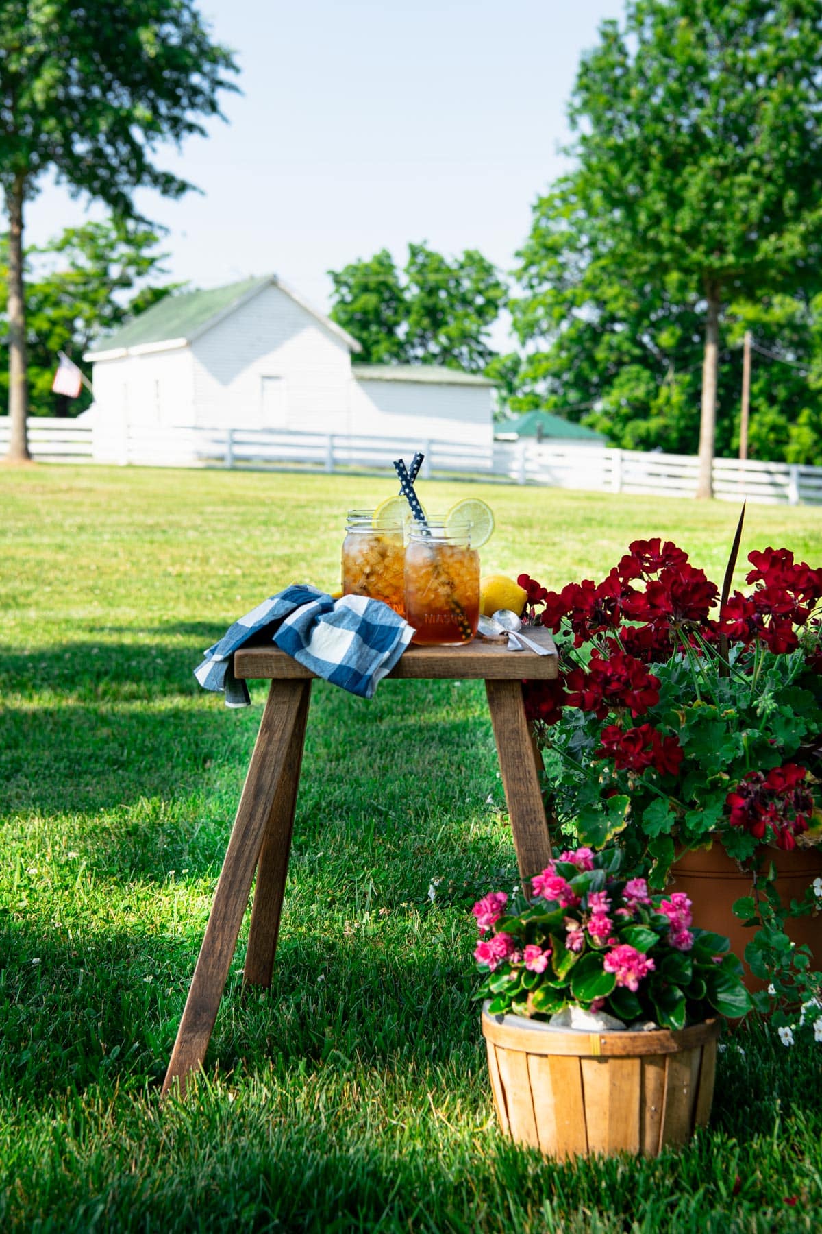 Table in a yard with two glasses of sun tea.
