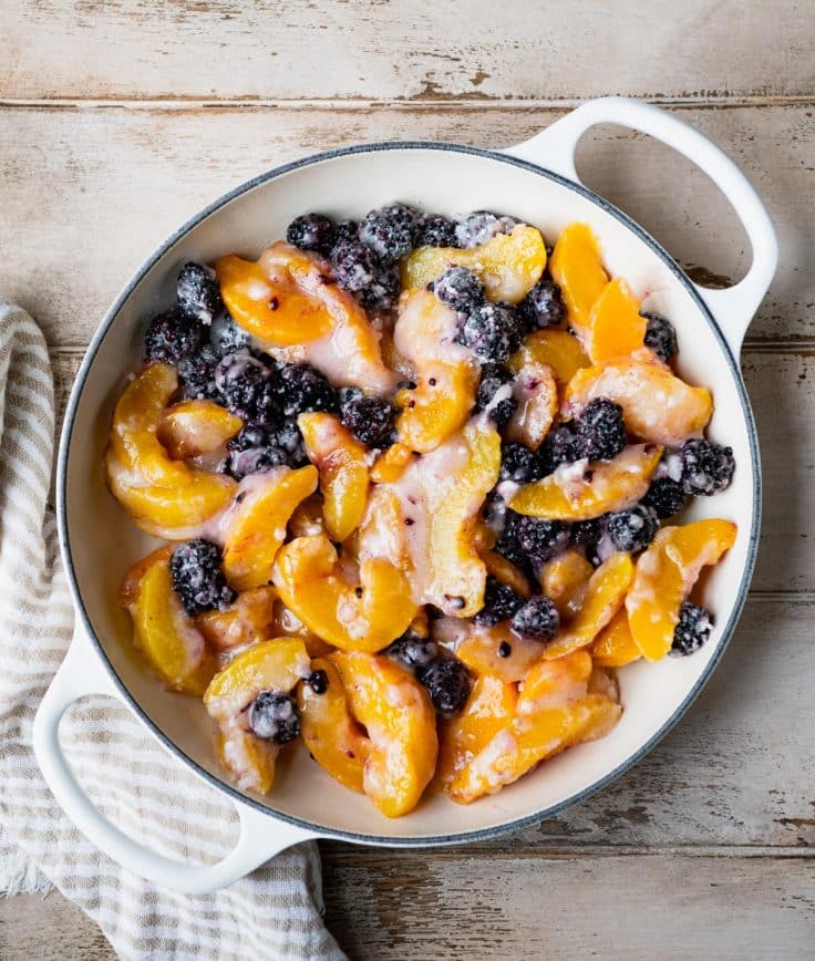 Peaches and blackberries in a cast iron skillet.