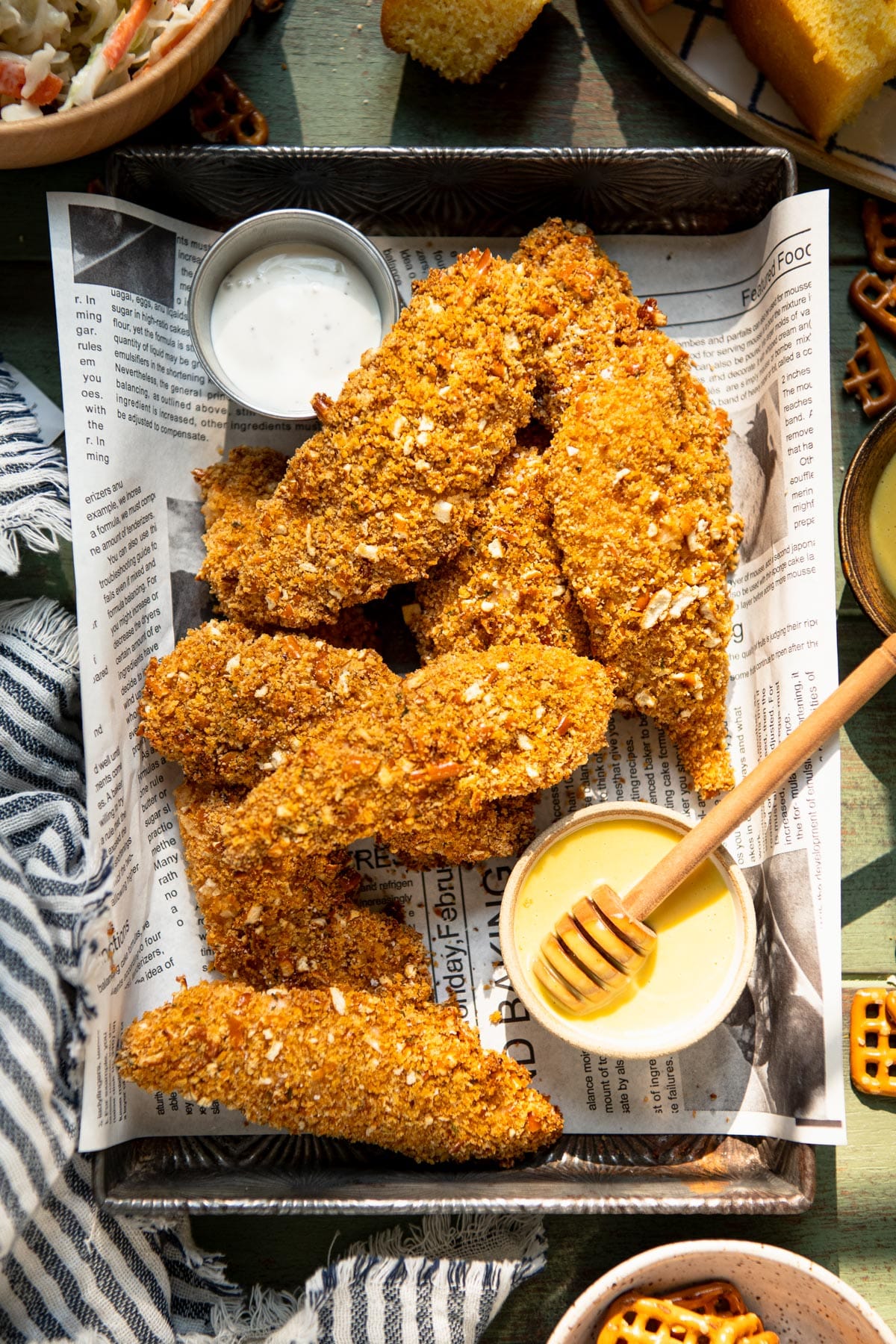 Overhead image of pretzel coated chicken strips served with honey mustard sauce.