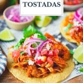 Tostadas de tinga (chicken tostadas) on a cutting board with text title overlay.