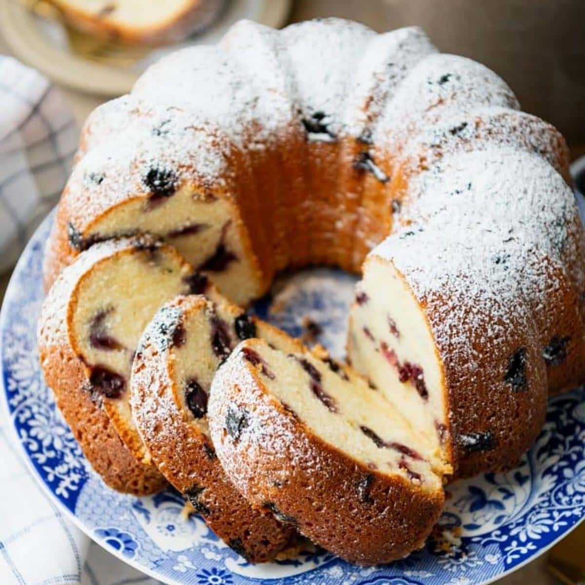 Sliced blueberry pound cake dusted with powdered sugar.