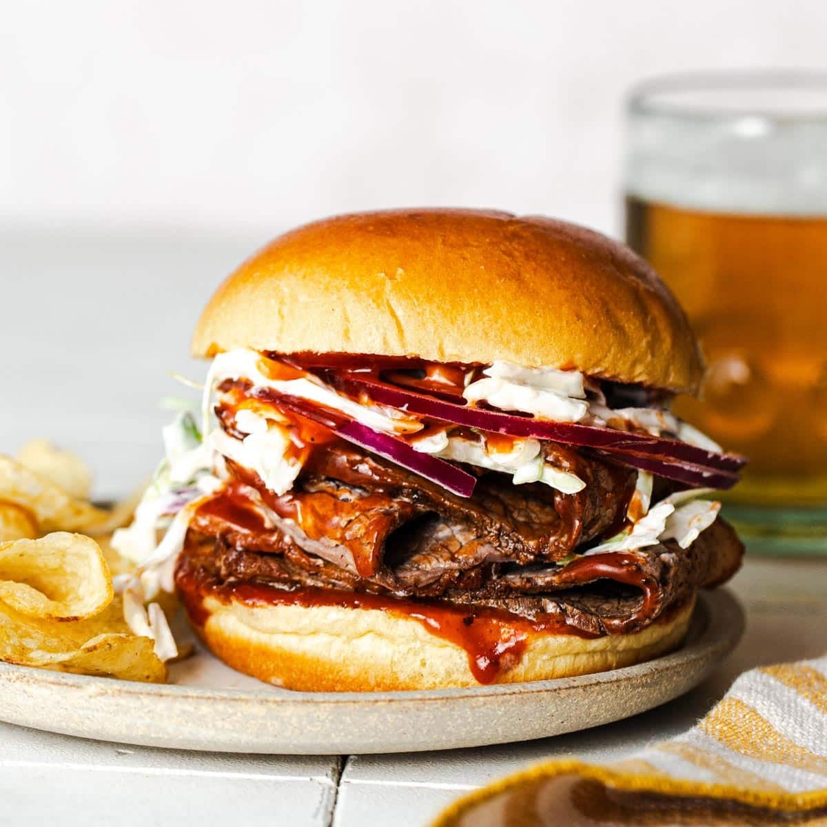 Square side shot of a Crock Pot brisket sandwich on a plate.
