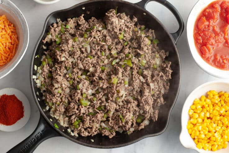 Browned ground beef and veggies in a skillet.