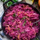 Serving spoon in a pan of braised red cabbage.