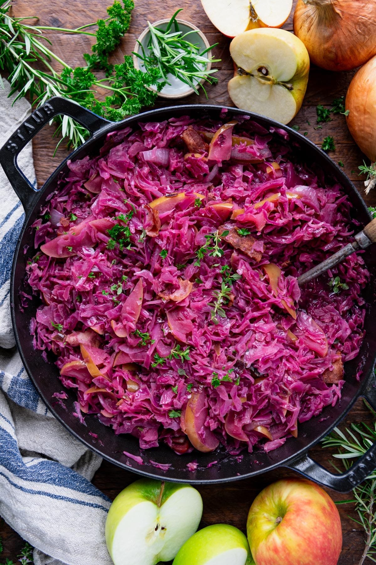 Overhead shot of braised red cabbage in a skillet with fresh herbs.