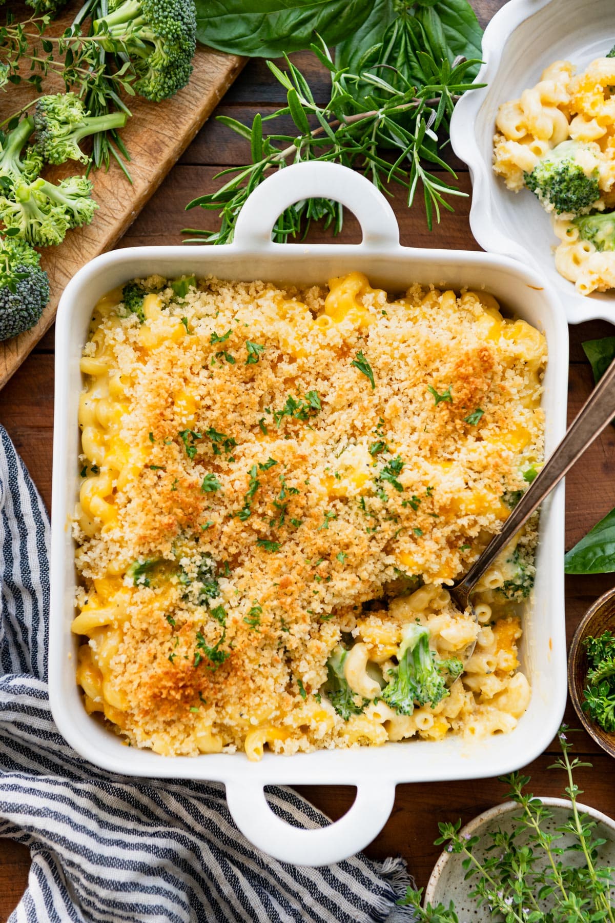 Spoon in a white dish full of broccoli cheddar mac and cheese recipe.