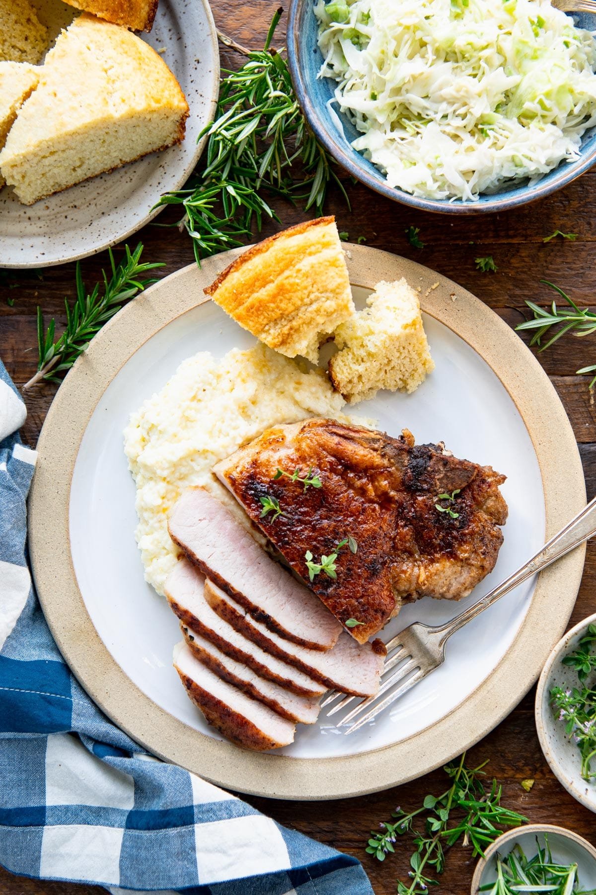 Overhead image of a plate of Cajun pork chops sliced and served with grits.