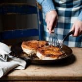 Pan frying pork chops in a cast iron skillet.