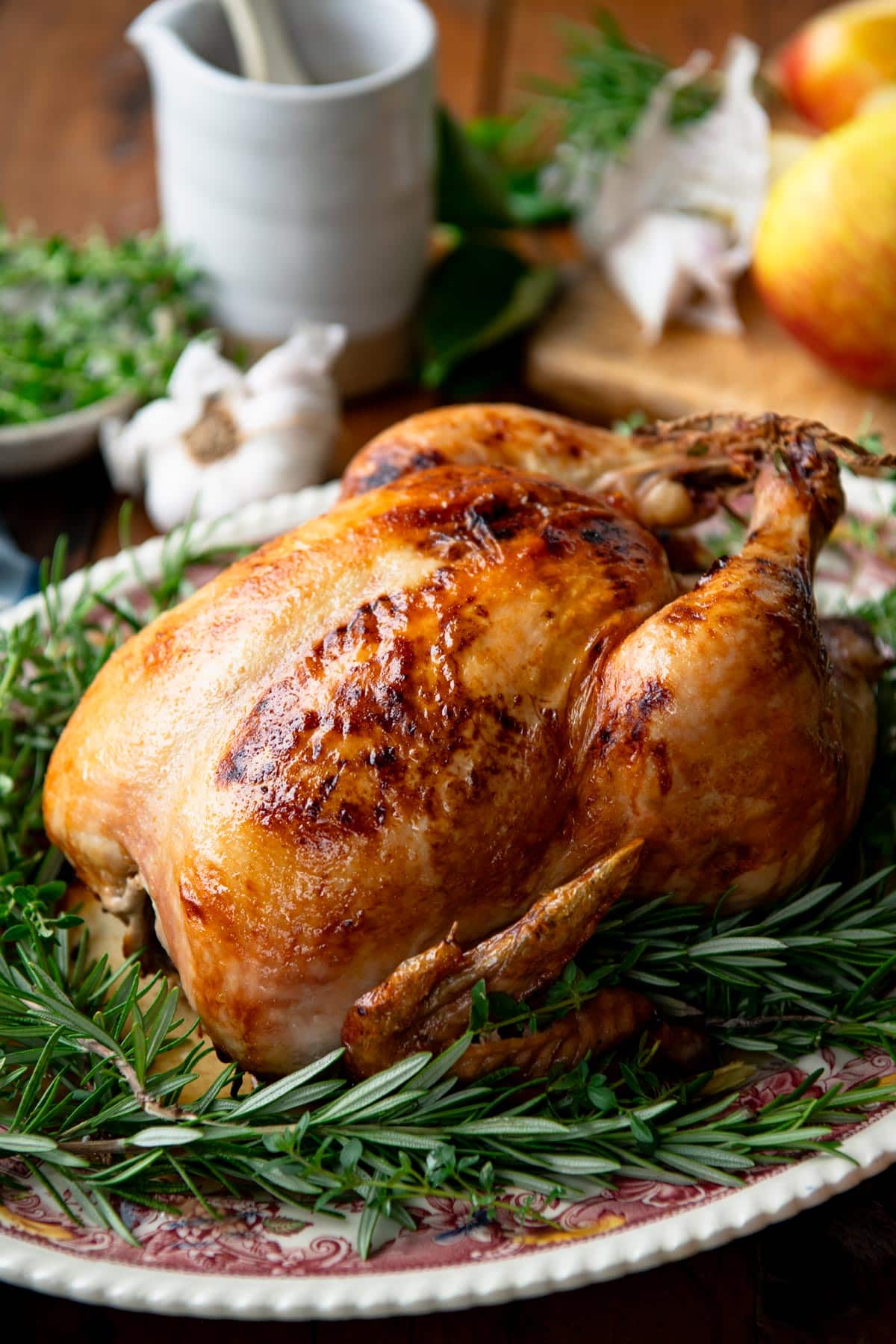 Close up side shot of a roasted chicken with crispy, golden brown skin.