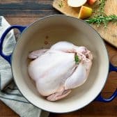 Whole chicken in a Dutch oven before roasting.
