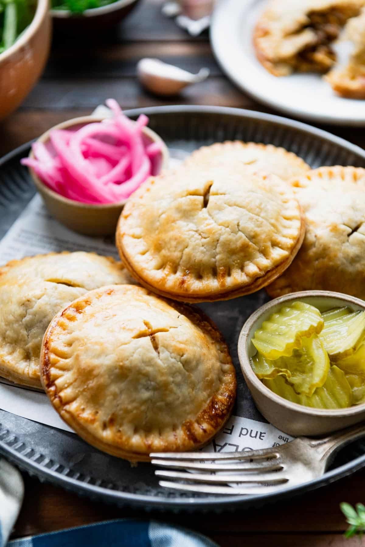 Ground beef and cheddar meat pies on a metal serving tray.