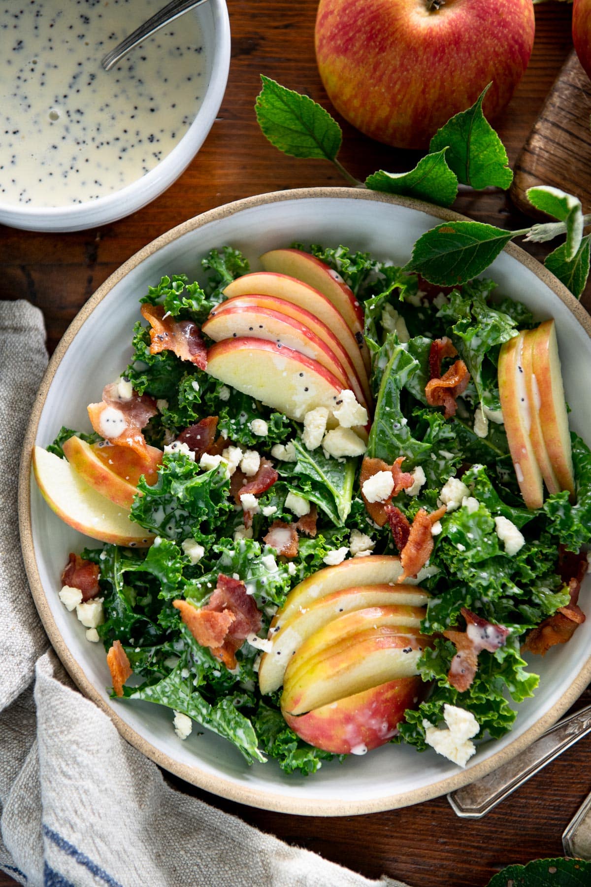 Close overhead image of apple kale salad with bacon and cheese.