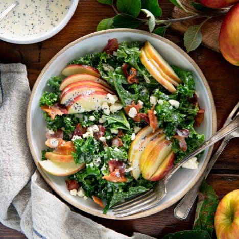 Square overhead shot of kale apple salad with bacon and creamy poppy seed dressing.