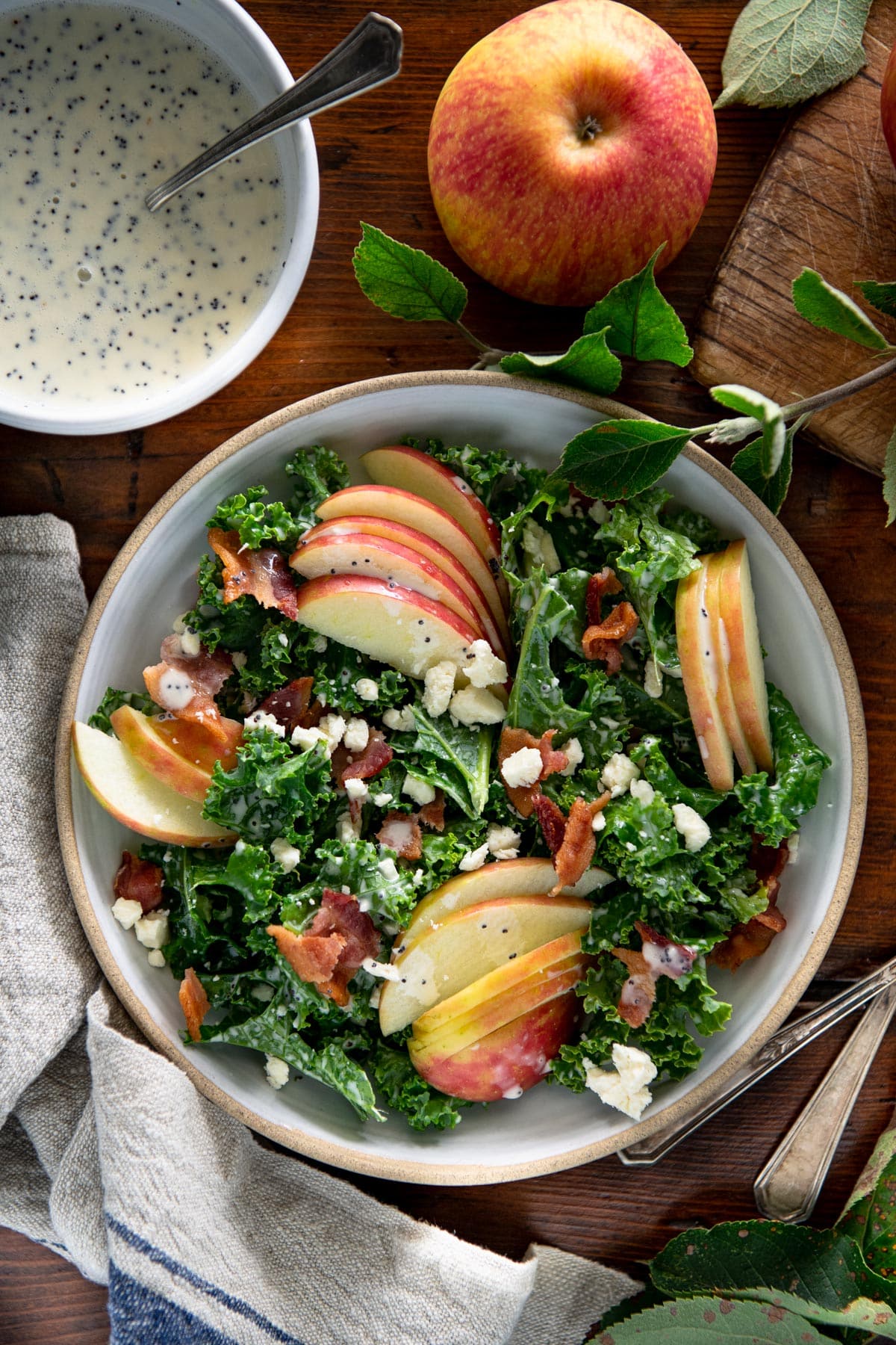 Bowl of apple kale salad on a wooden table.
