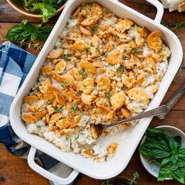 Square overhead shot of leftover turkey rice casserole in a white dish on a wooden table.