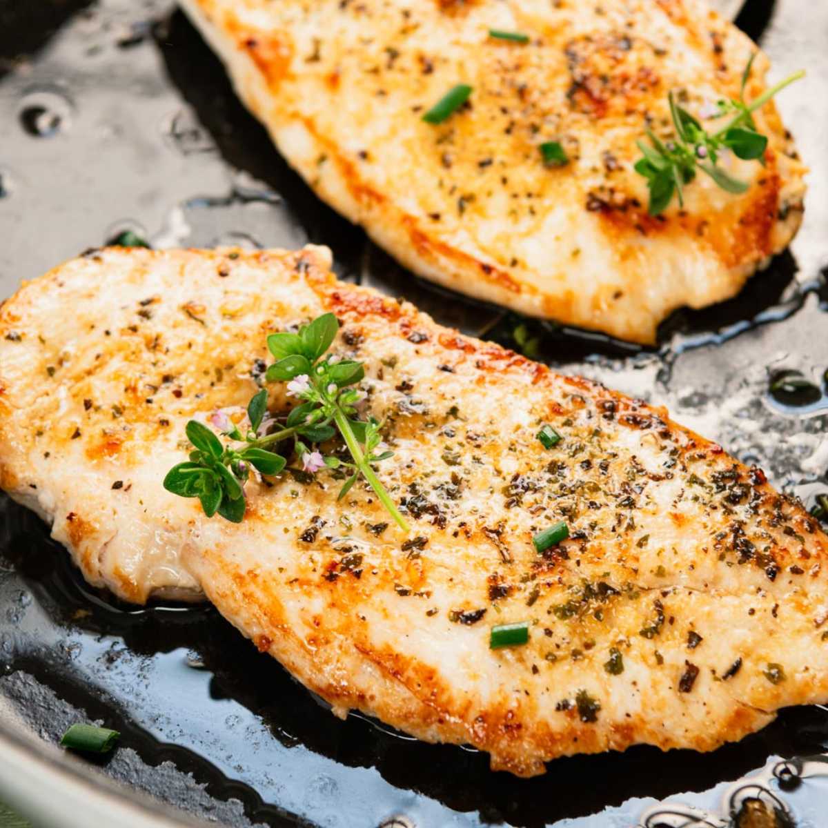 Close up square shot of a cast iron skillet chicken breast.