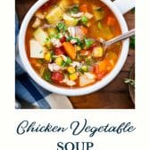 Bowl of chicken vegetable soup with text title at the bottom.