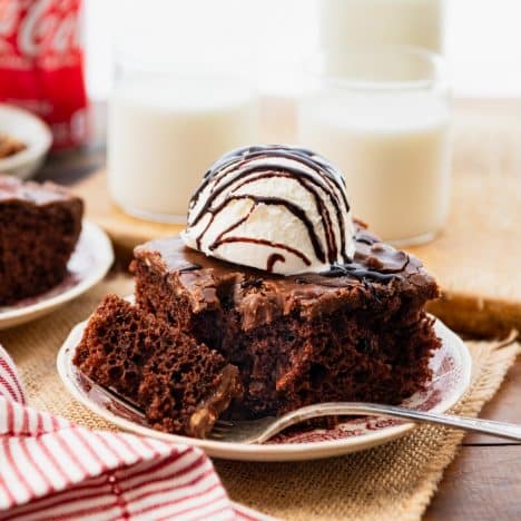 Square side shot of coca cola cake with cake mix on a red and white plate.