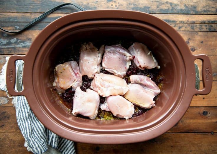 Process shot showing how to make cranberry chicken in a crock pot.