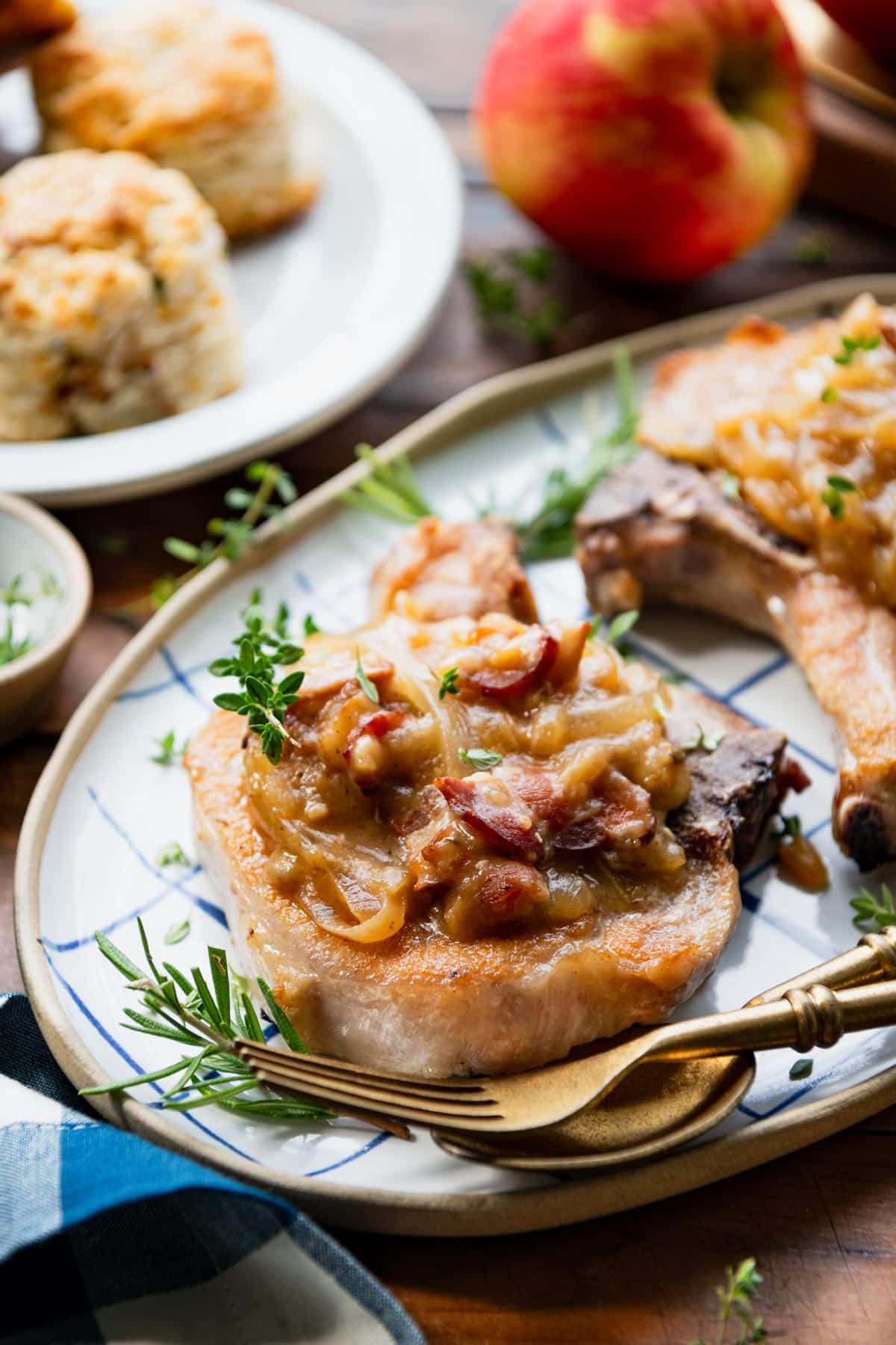 Side shot of smothered Crock Pot pork chops on a serving platter.