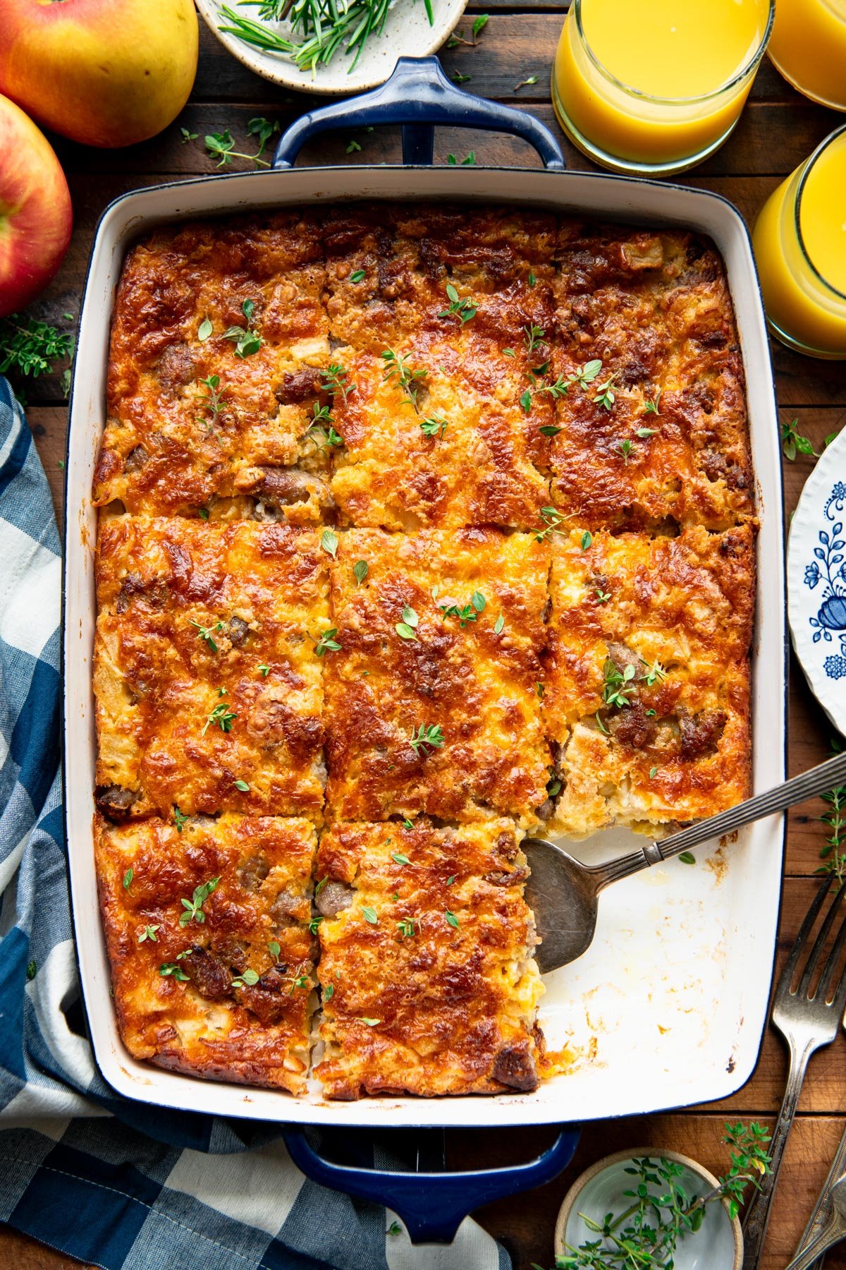 Sliced maple sausage and apple breakfast bake on a wooden table.
