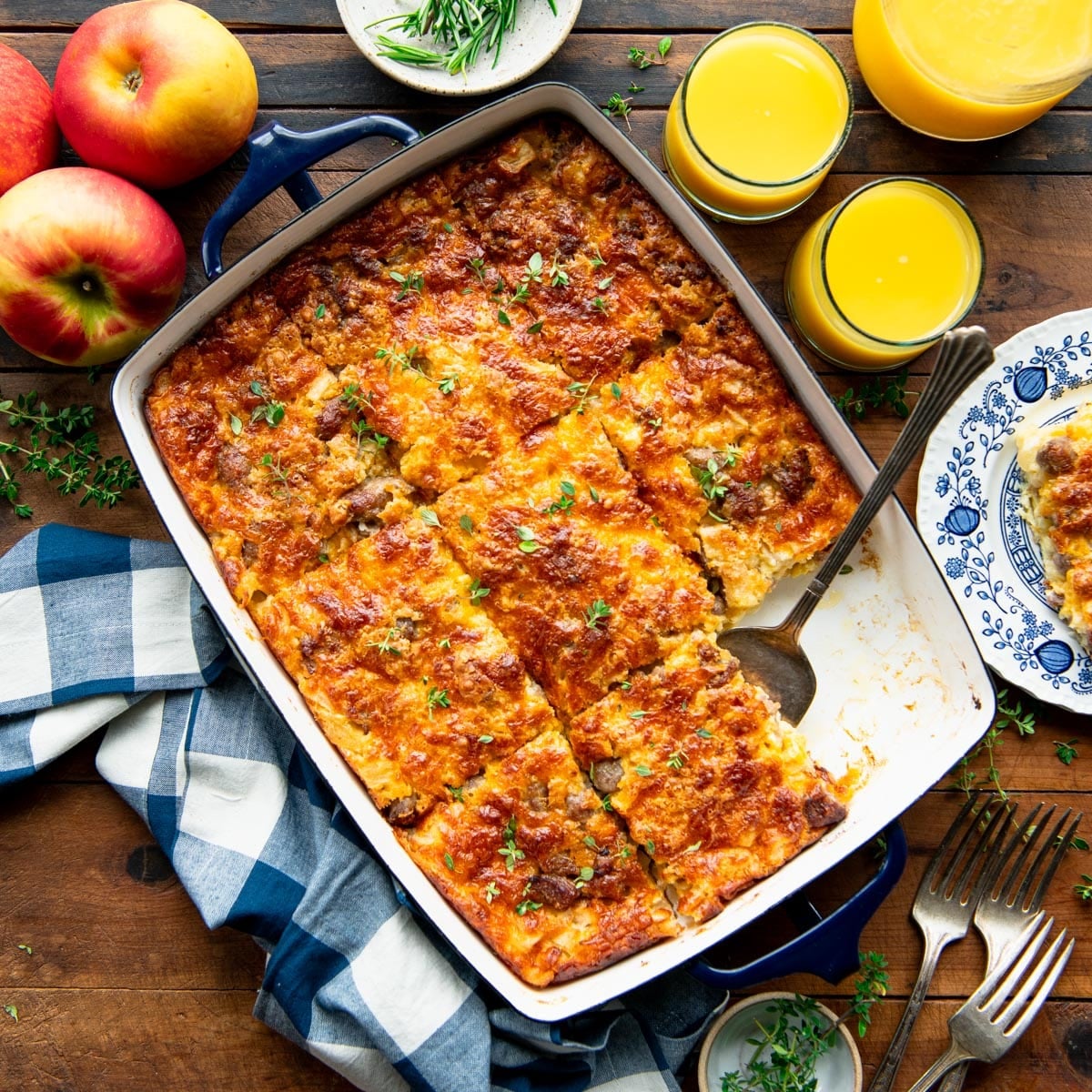 Square overhead shot of a pan of sausage and apple breakfast bake on a wooden table.