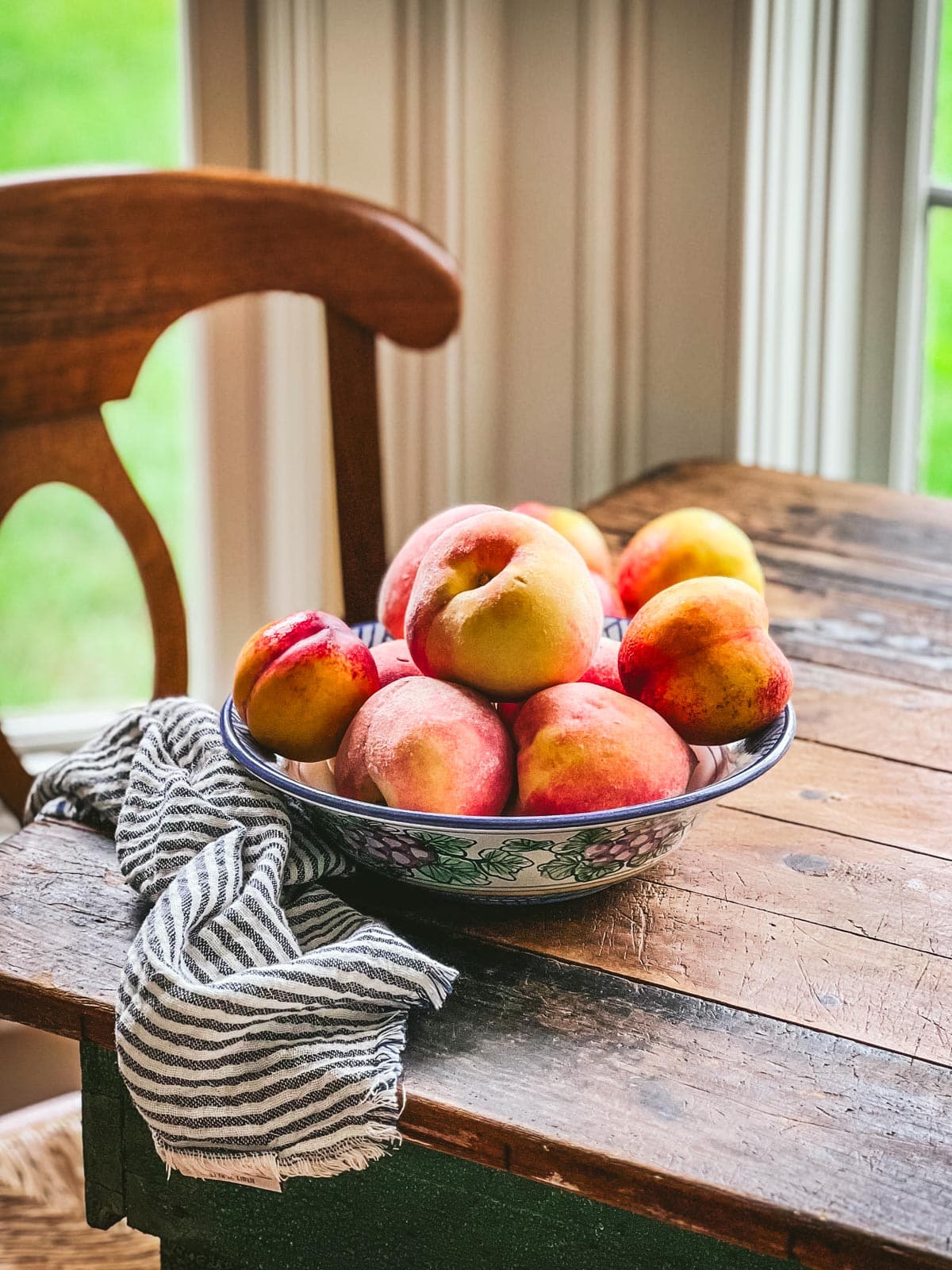 Bowl of peaches and nectarines on a farmhouse table