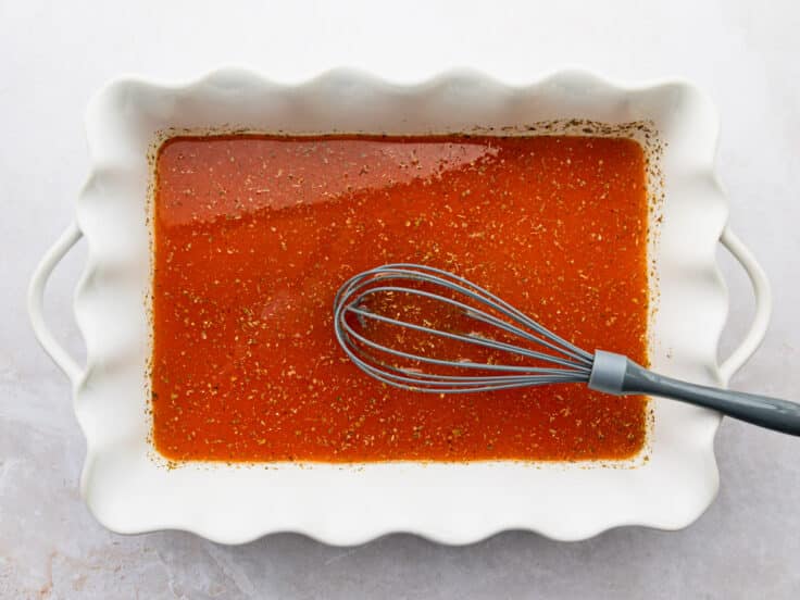 Whisking together the sauce and seasoning in the baking dish.