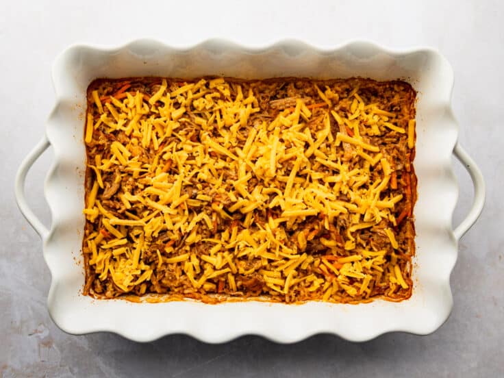 Adding cheese to the top of the casserole.