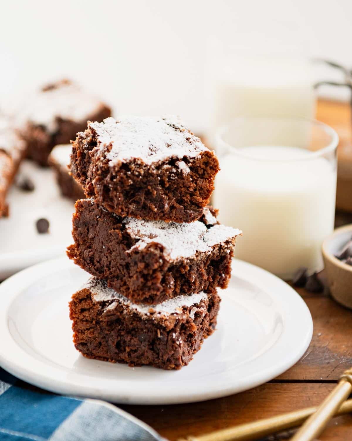 Side shot of three one bowl brownies stacked on a white plate.