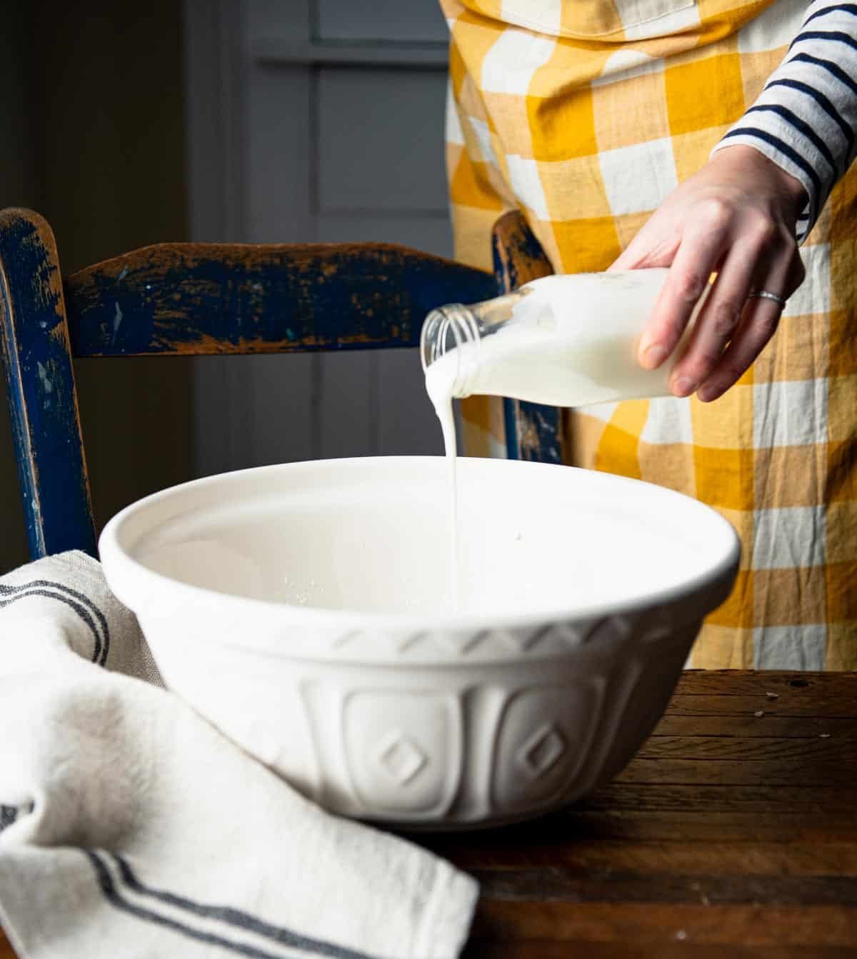 Pouring buttermilk in a mixing bowl.
