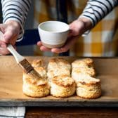 Brushing 3 ingredient biscuits with melted butter.