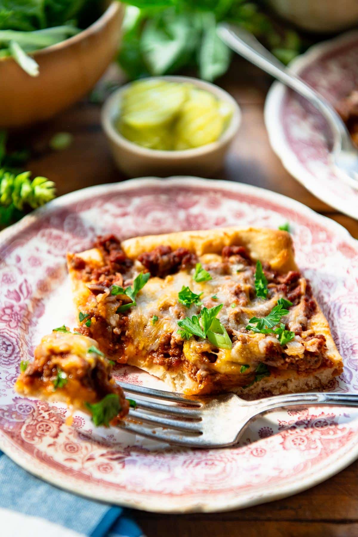 Slice of easy sloppy joe casserole on a plate with a bite on a fork.