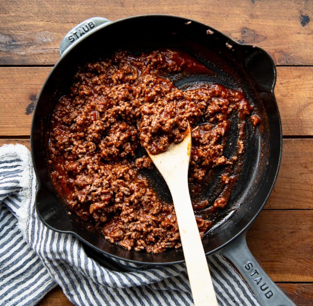 Sloppy joe sauce and ground beef in a cast iron skillet.