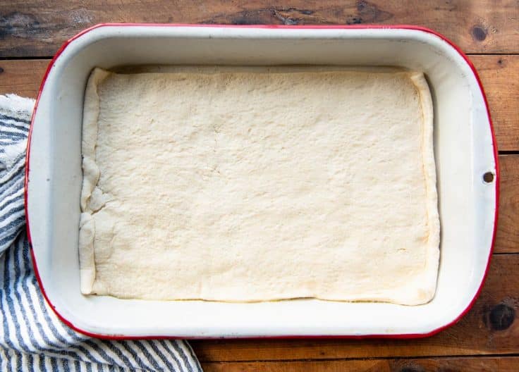 Crescent roll dough pressed into the bottom of a baking dish.