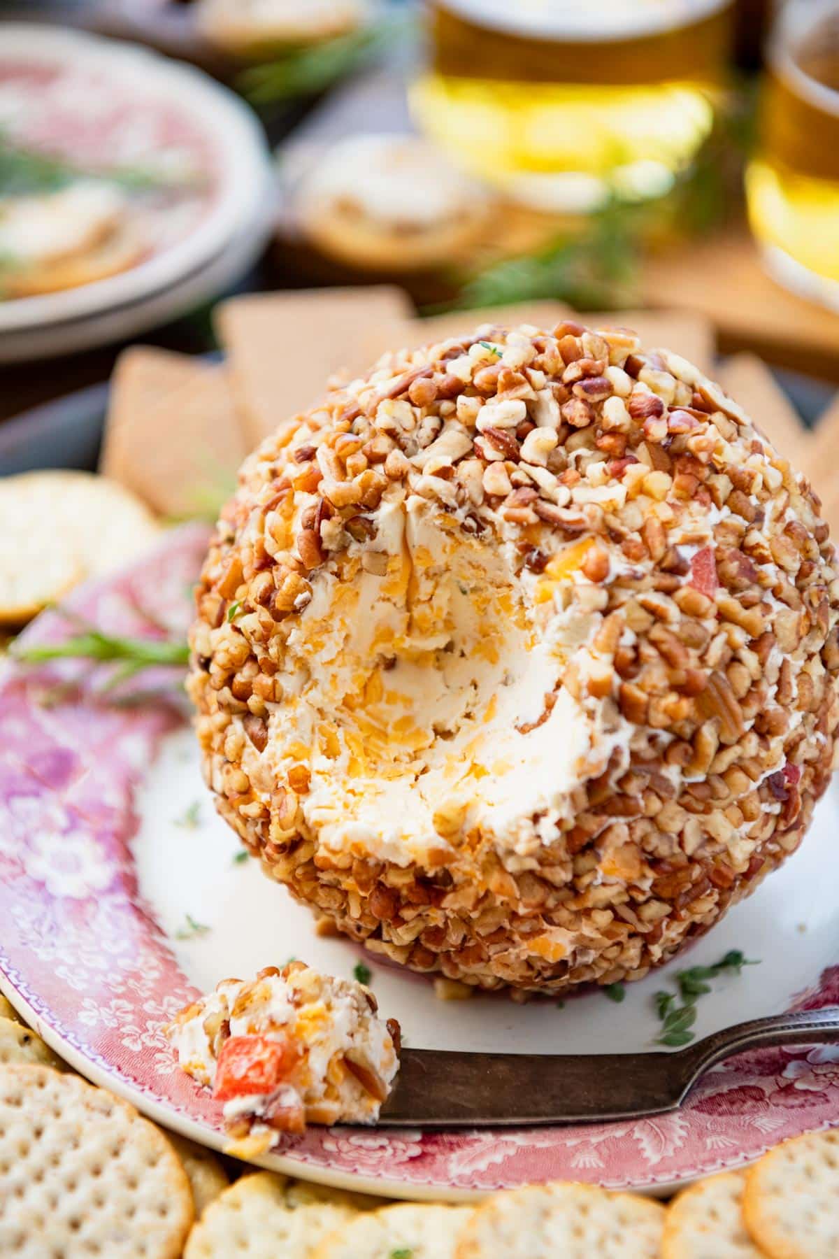 Side shot of an easy cheese ball recipe on a red and white plate.