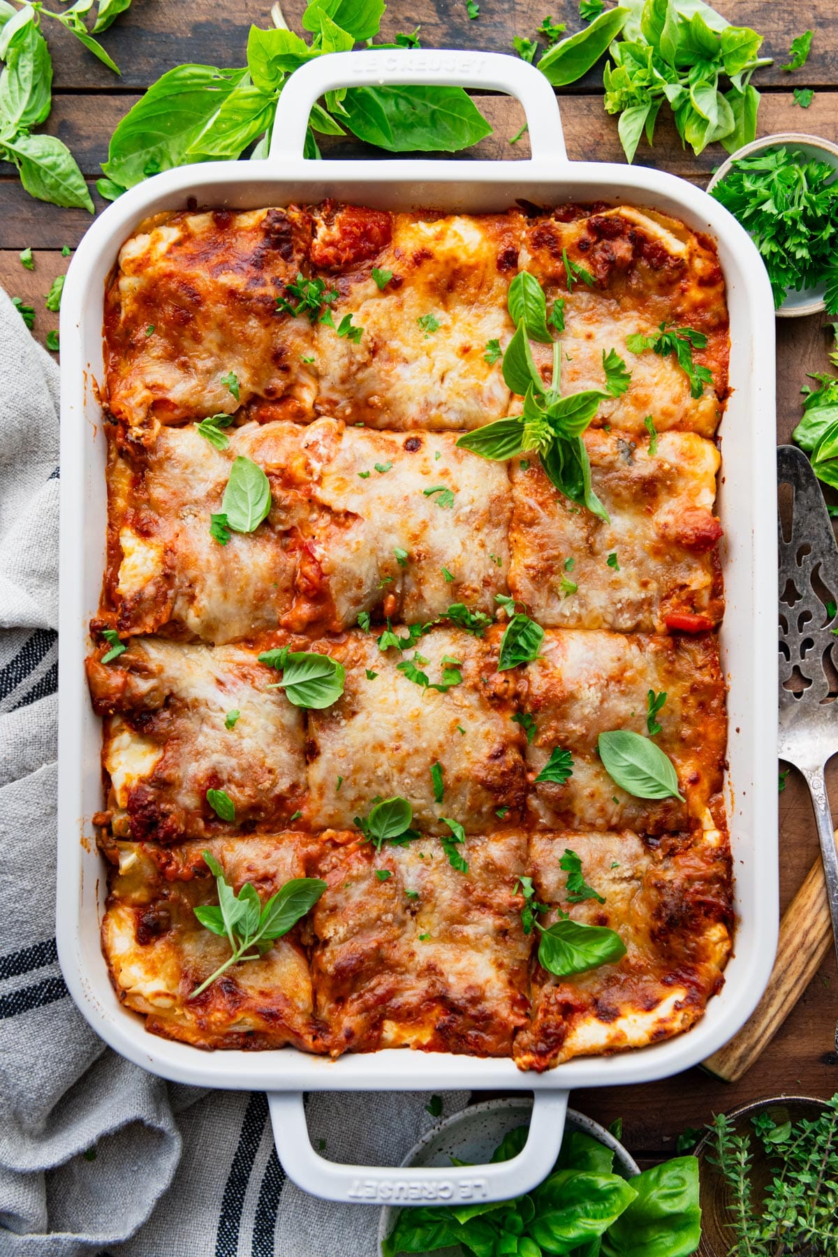 Classic lasagna recipe baked in a white dish and sliced into squares.