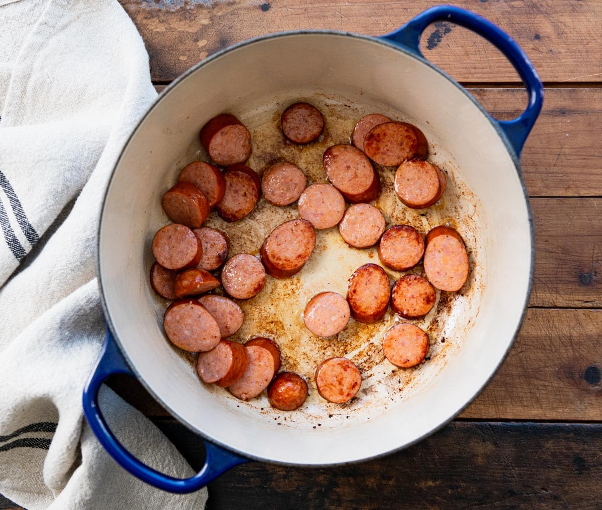 Browning andouille sausage in a pot.