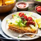Easy chicken quesadilla casserole served on a plate with salsa, lettuce, and tomatoes.