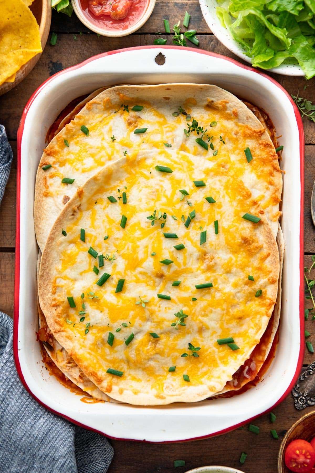Overhead shot of a simple chicken quesadilla casserole in a vintage baking dish on a table.