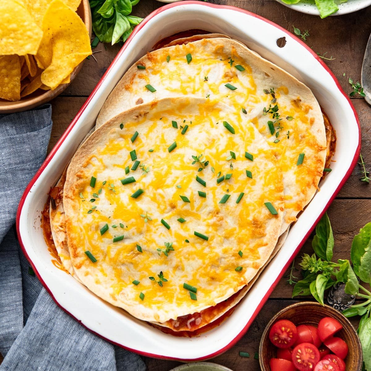 Square overhead shot of healthy chicken quesadilla casserole in a red and white baking dish.