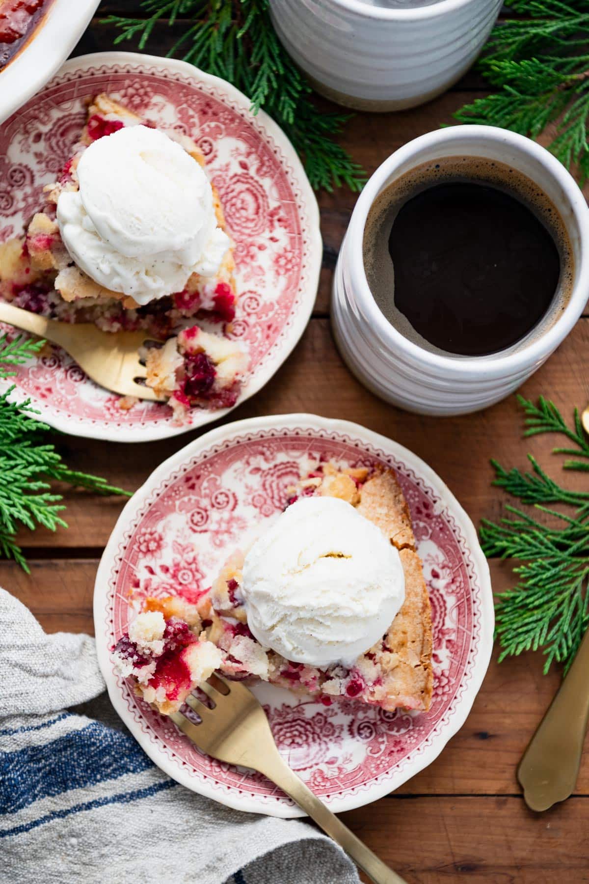 Fresh cranberry pie sliced and served on red and white plates.